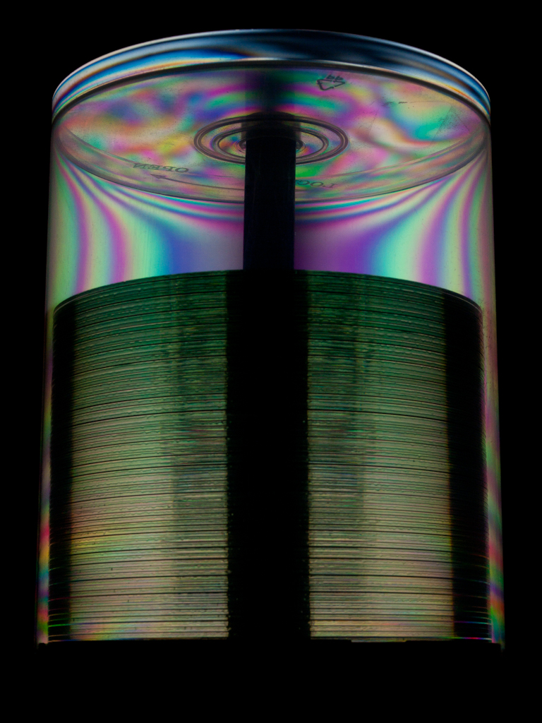 Stack of CDs in a spindle, where the colours of the casing are visible